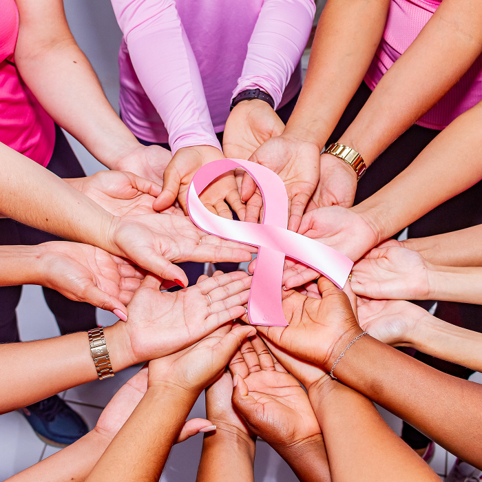 many hands holding breast cancer ribbon