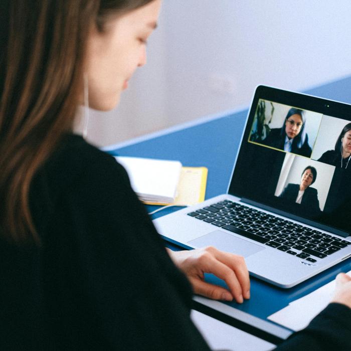 woman sitting on a video call and taking notes