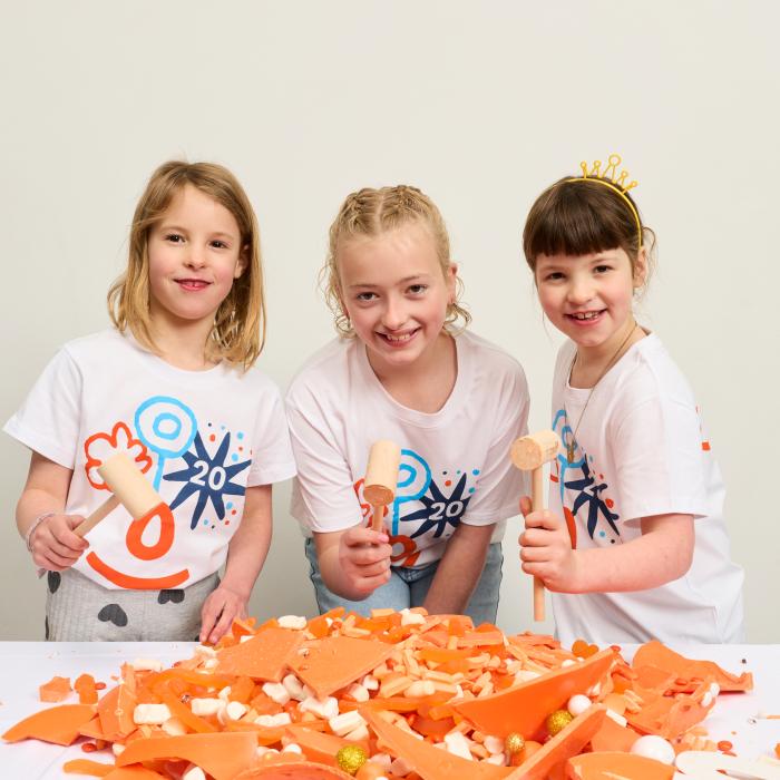 three young girls enjoying a smash cake